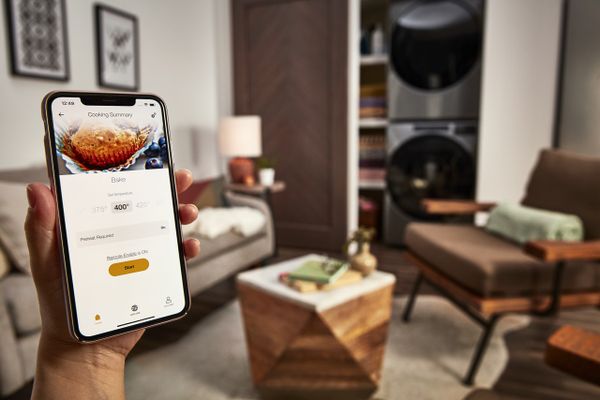 A user using the Wi-Fi programming on a smart device for a Whirlpool oven 