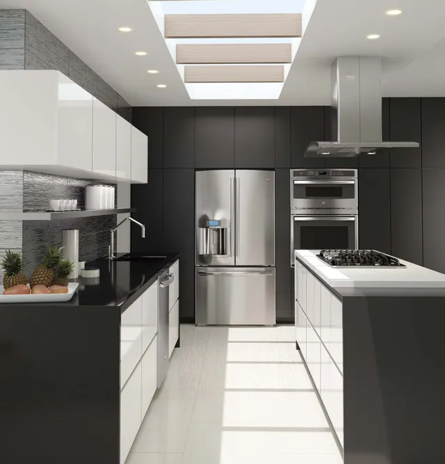 A kitchen with black and white cabinets and GE Profile kitchen appliances