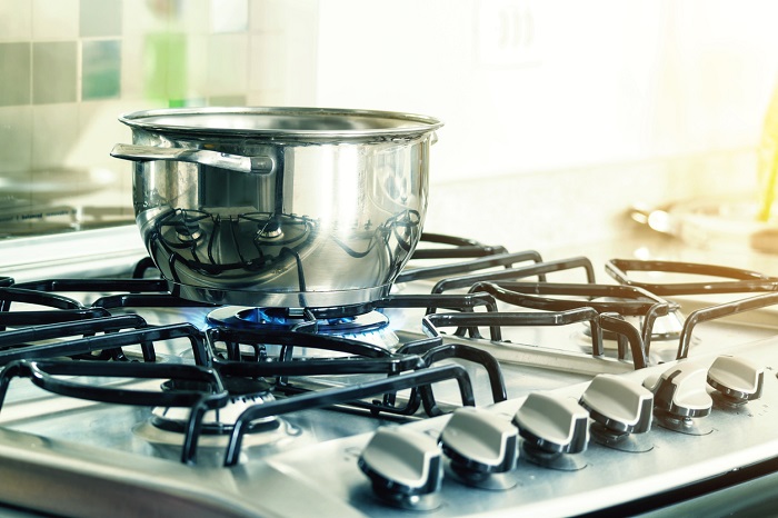 Metal pan boiling water on a gas stove. 