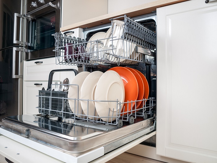 Dishwasher close-up with washed dishes in modern kitchen. 