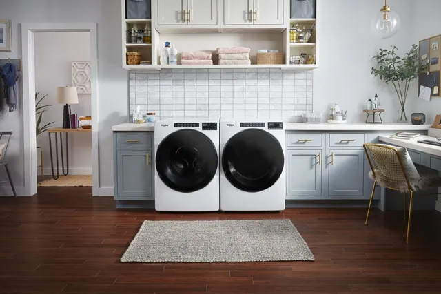White Whirlpool front load washer and dryer in a well appointed laundry room