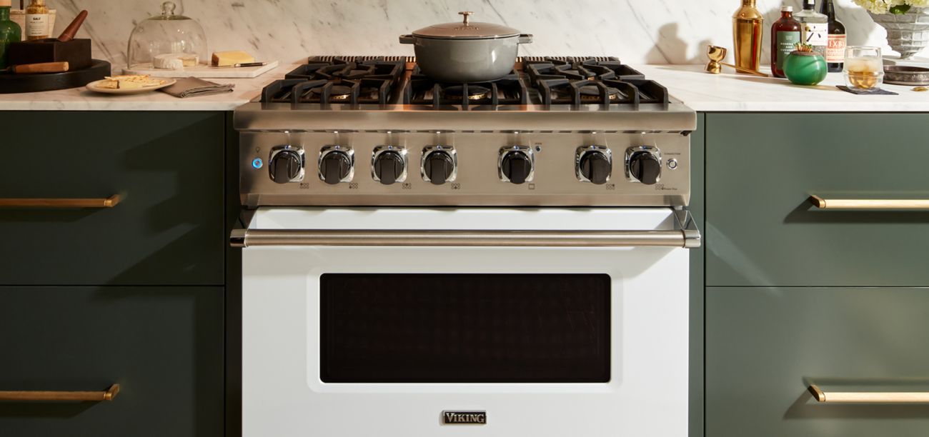 Close up shot of a Viking gas range nestled between a kitchen countertop.