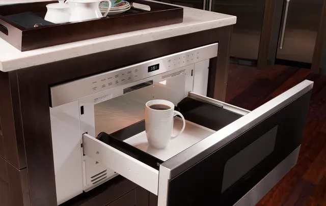 The Wolf MD30TE/S microwave drawer shown open with a glass of coffee inside 
