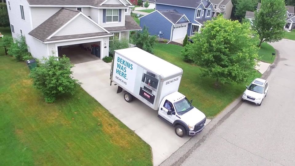A Bekins hault truck outside of a home 