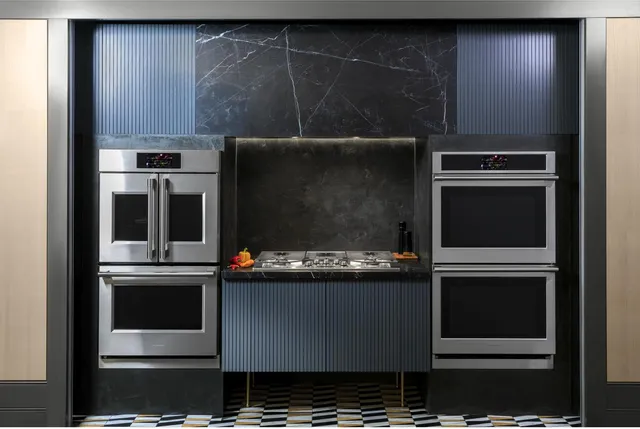 Stainless steel Monogram double wall ovens installed in a luxury kitchen