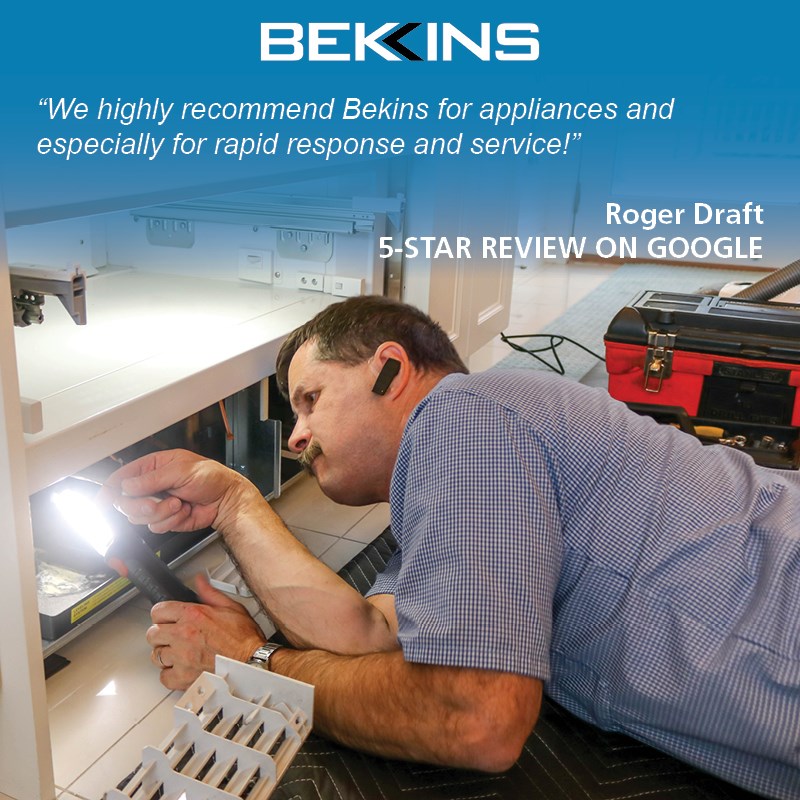 A Bekins repair technician fixing a refrigerator 