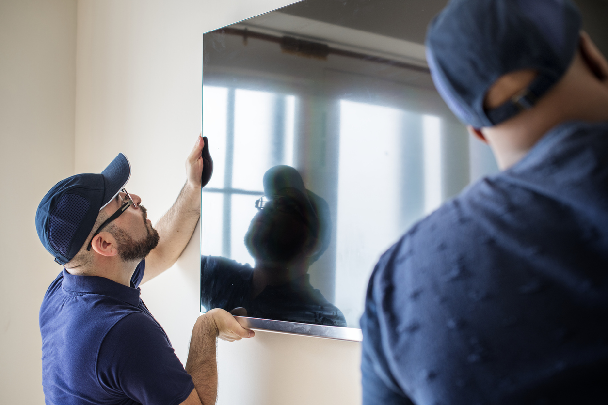 Two men installing a smart TV. 