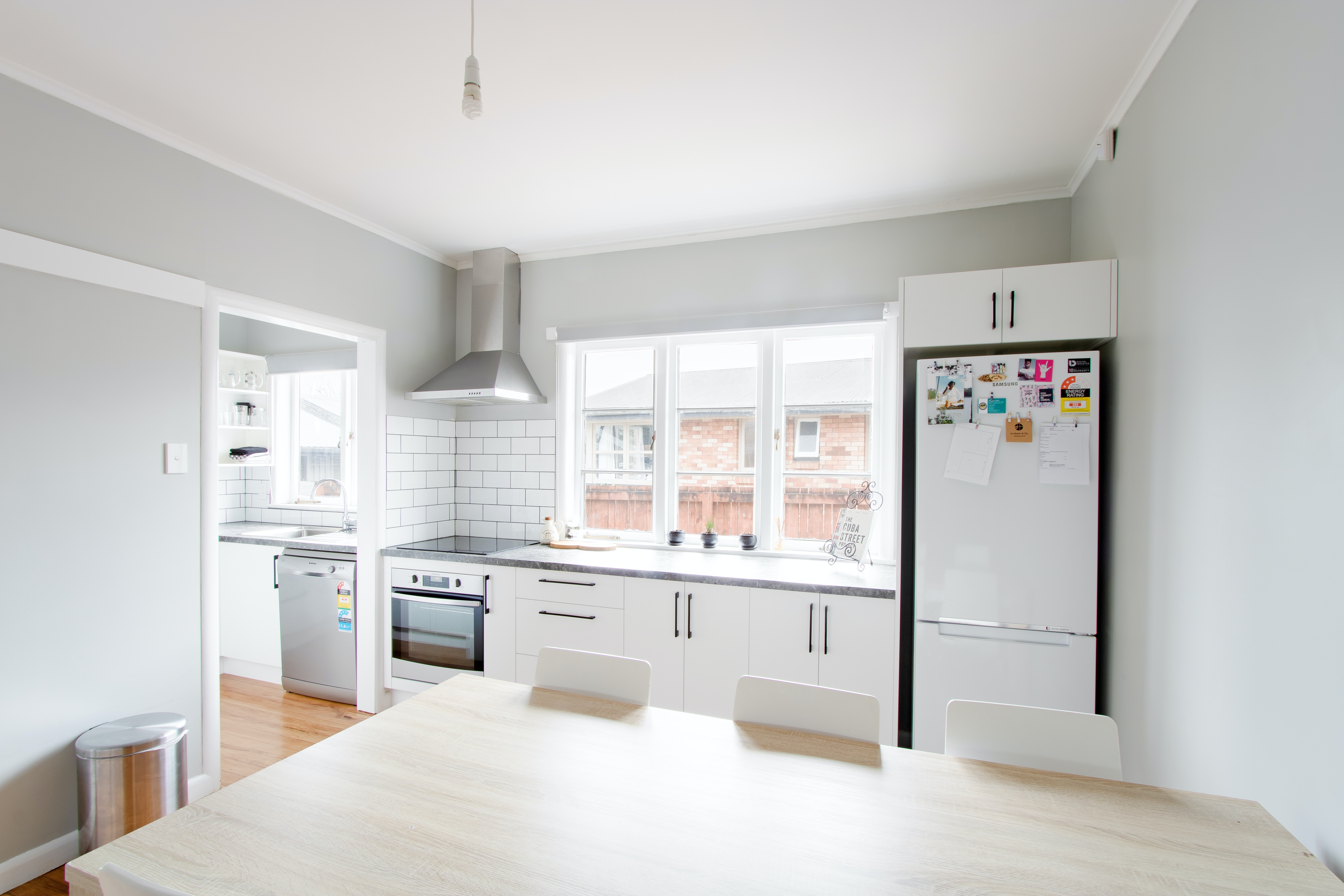 A simple white kitchen with black handles in an old train house.