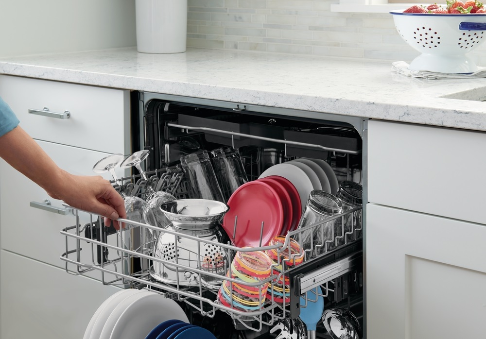 closeup of hand opening Frigidaire Gallery built in dishwasher