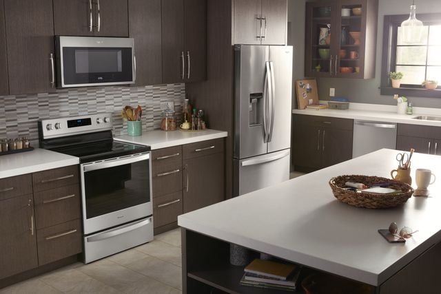 view of a modern kitchen with brown cabinets and stainless steel appliances, and a freestanding electric range 