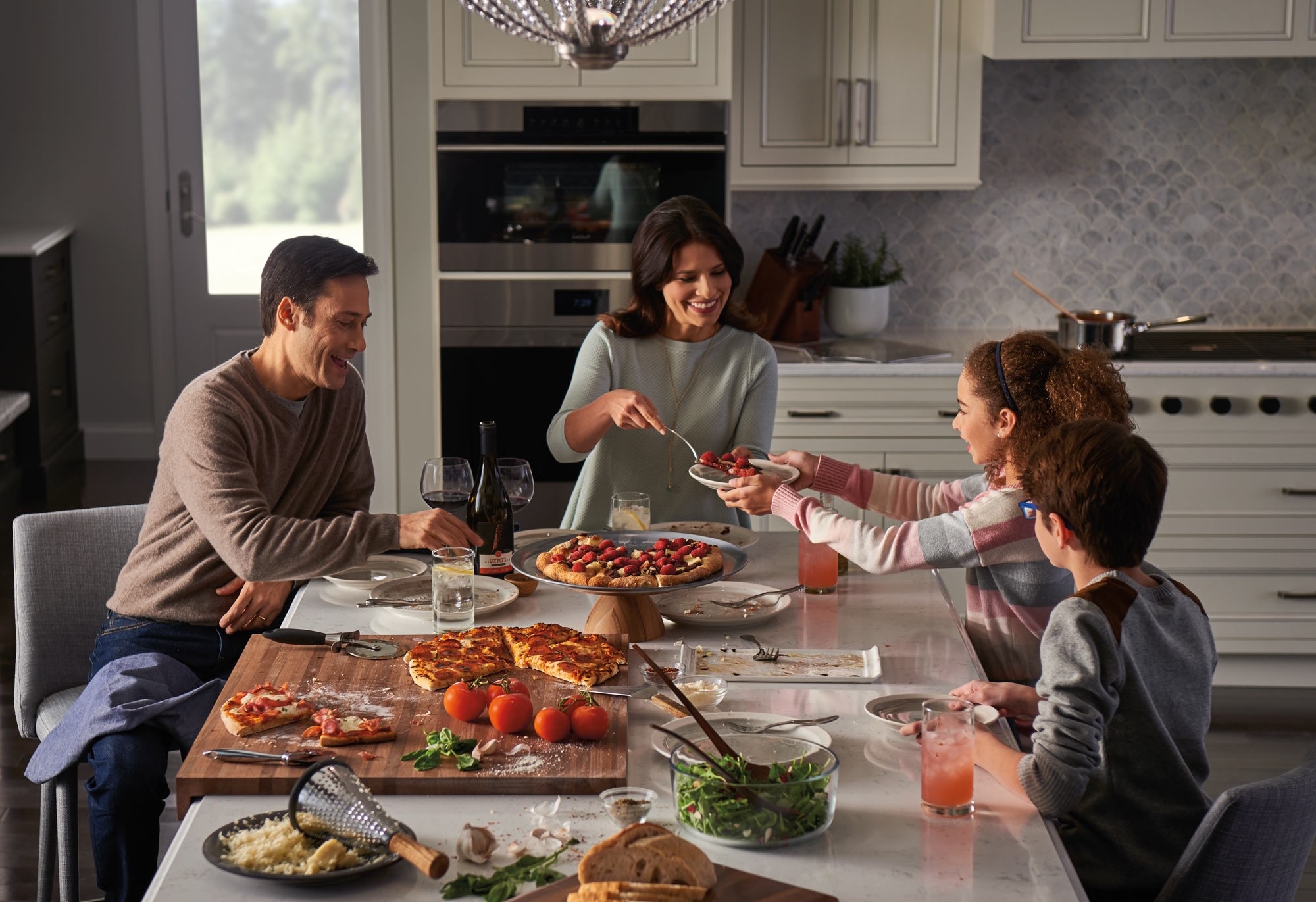 family enjoys meal together at home with Wolf wall ovens