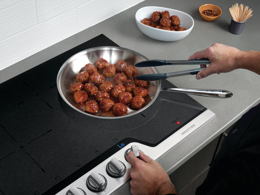 home cook uses Frigidaire Professional induction cooktop to sear meatballs