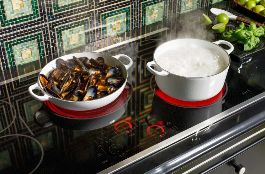 Cafe electric cooktop with a pot on top of it cooking mussels 