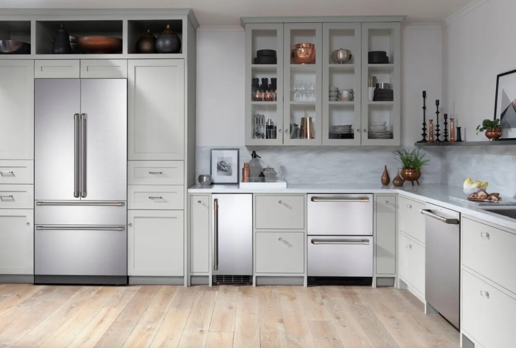Cafe stainless steel appliances in a kitchen with pale foam cabinets