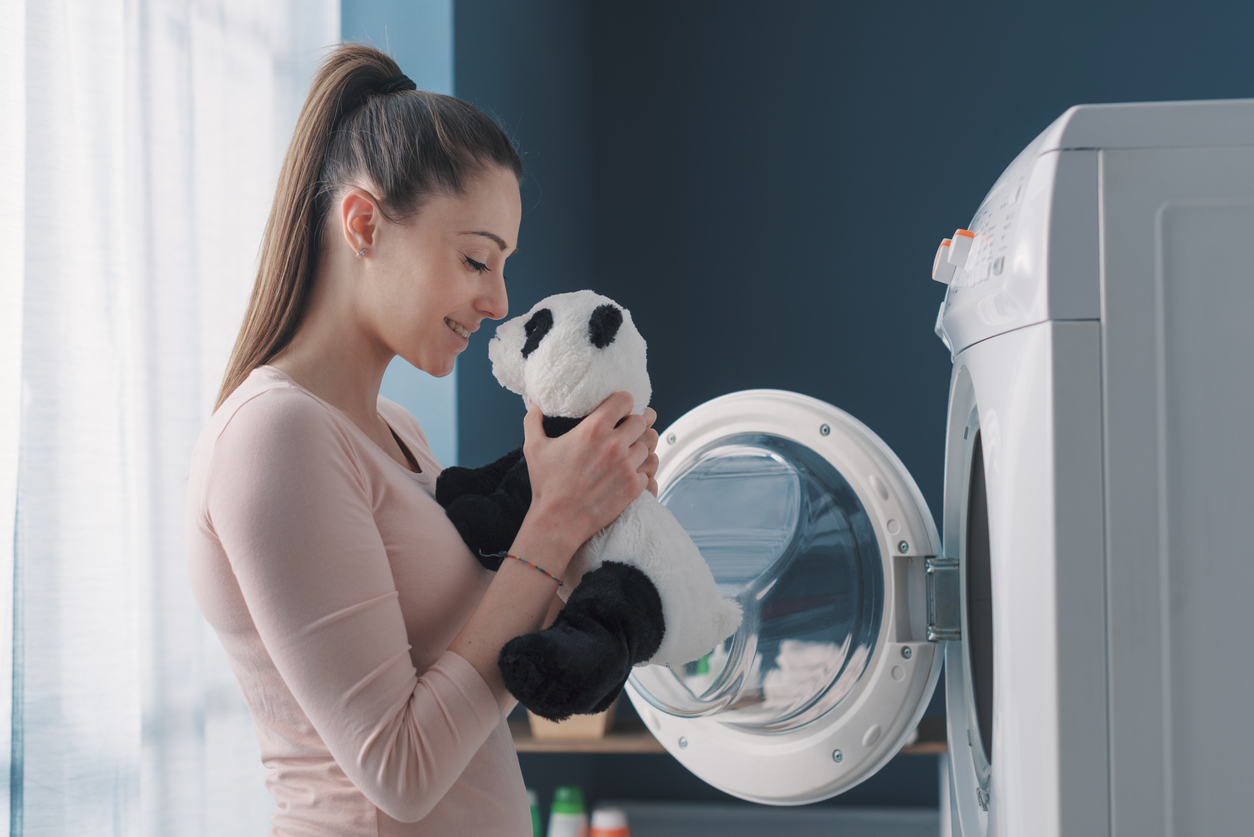 happy woman smelling her freshly washed panda plush