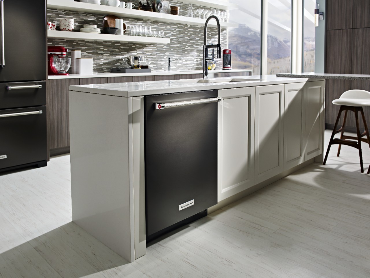 The KitchenAid KDTM704EBS black stainless steel dishwasher in a kitchen island 
