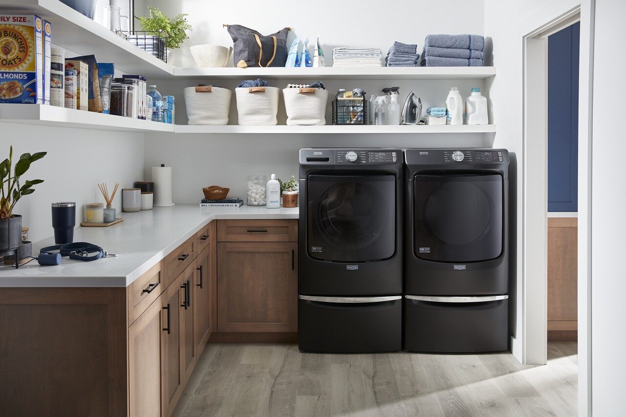 A matching Maytag black front load washer and dryer pair in a laundry room 