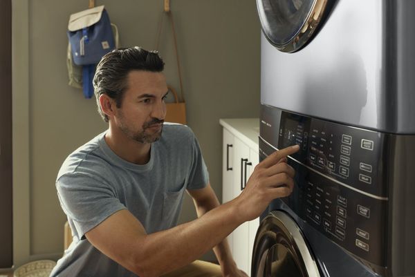 A man selecting a wash setting on an Electrolux washer 