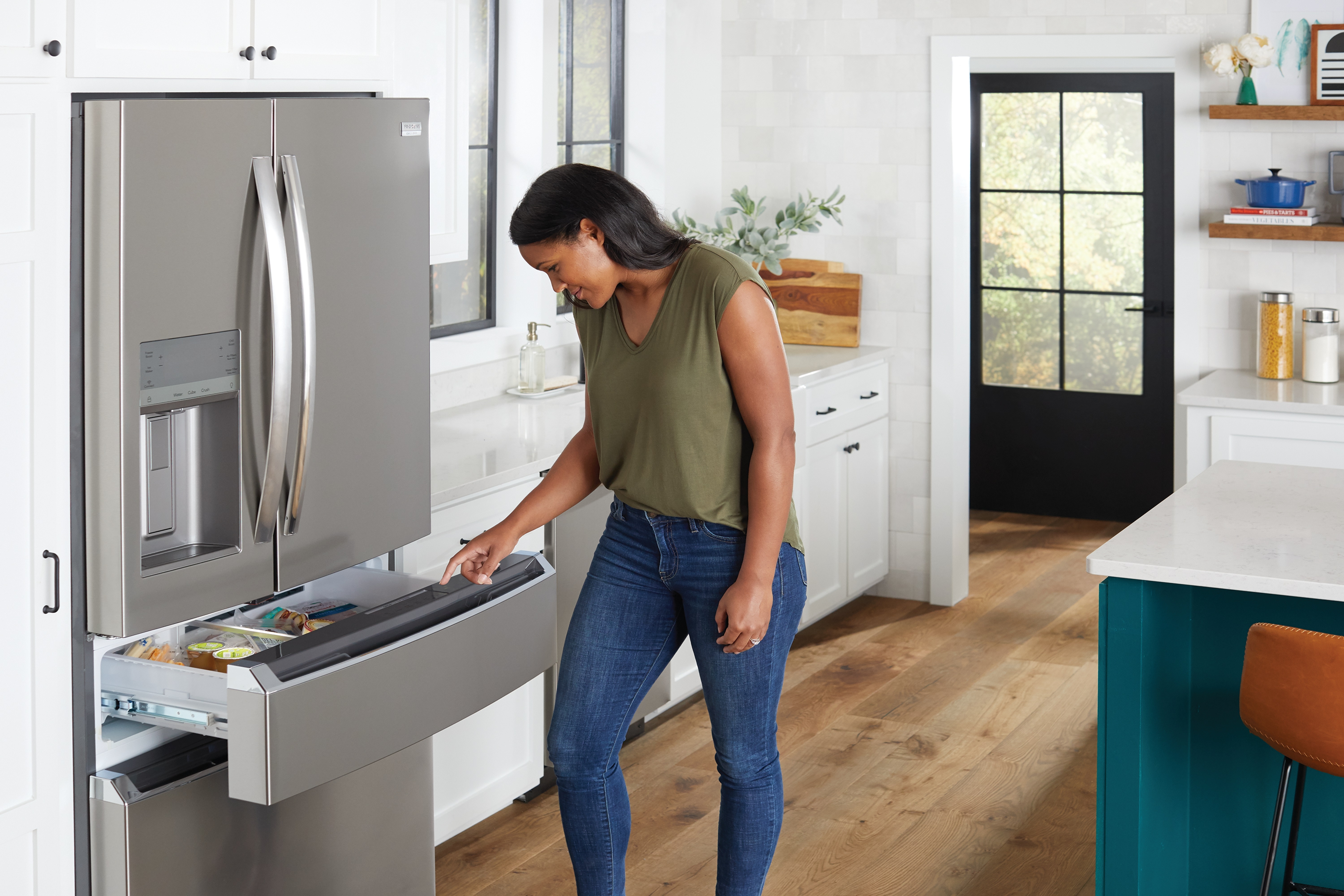 A woman grabbing an item from a Frigidaire Gallery French door refrigerator 