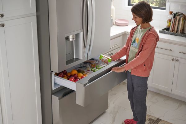 A young boy grabbing an item from the LG LF29H8330S refrigerator 