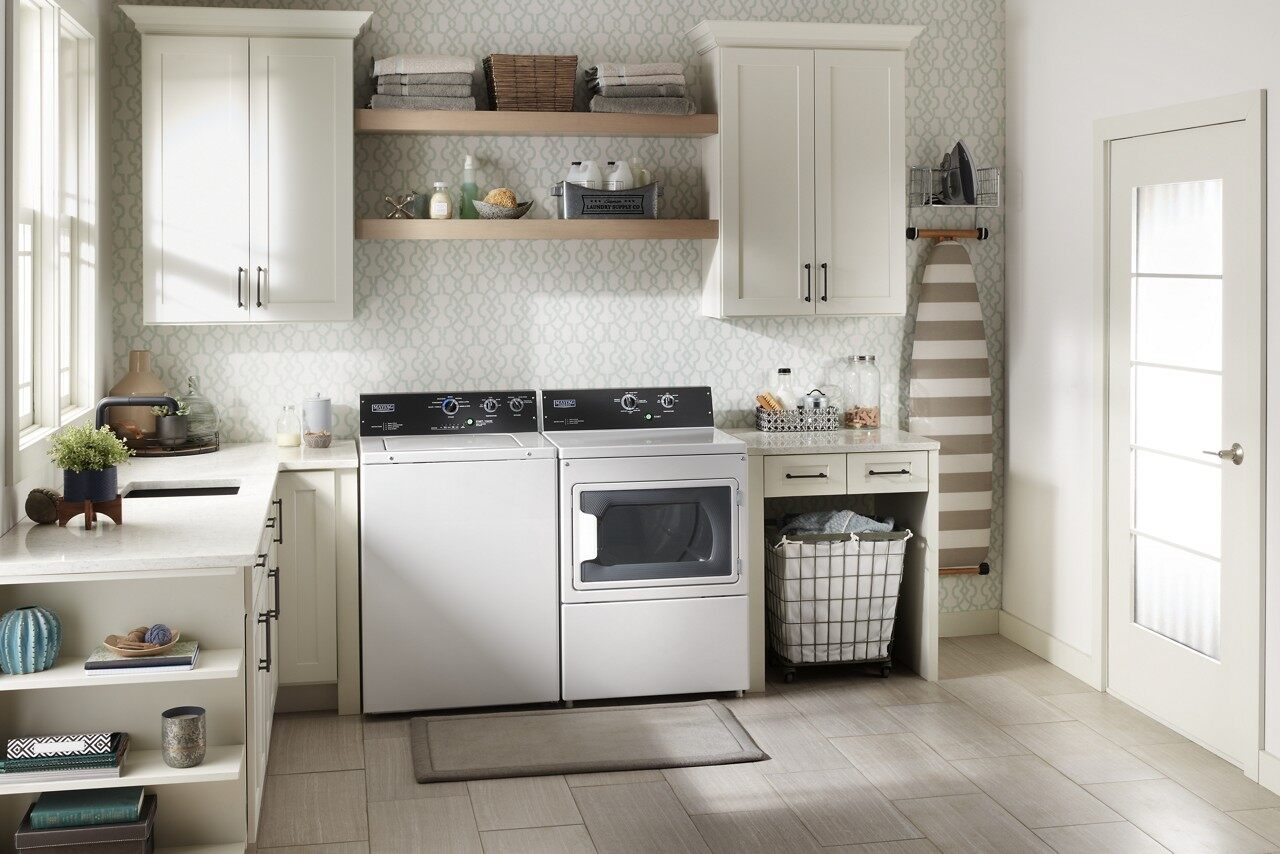 A laundry room featuring a matching Maytag top load washer and dryer 