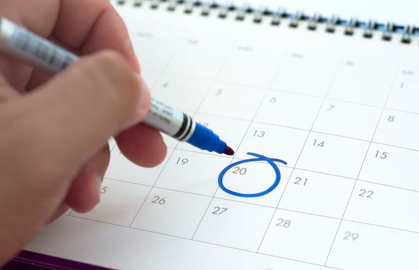A person circling a date on a calendar 