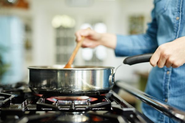 A close-up of someone cooking on a gas stove 