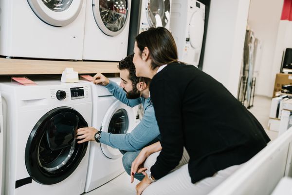 A man and a woman inspecting a front load washer