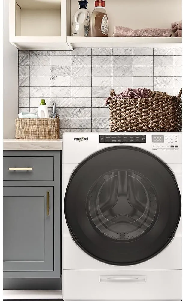 The Whirlpool WFC682CLW washer dryer combo in a laundry room with décor 