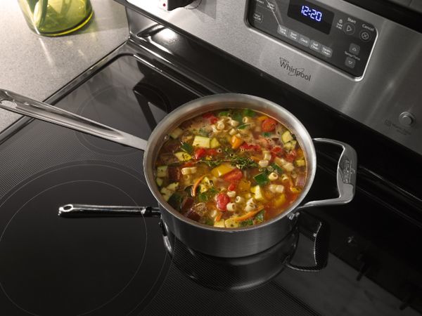 A pot of soup cooking on a Whirlpool electric range