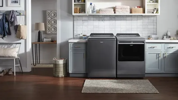 The Whirlpool WTW8127LC top load washer with a matching dryer in a laundry room 