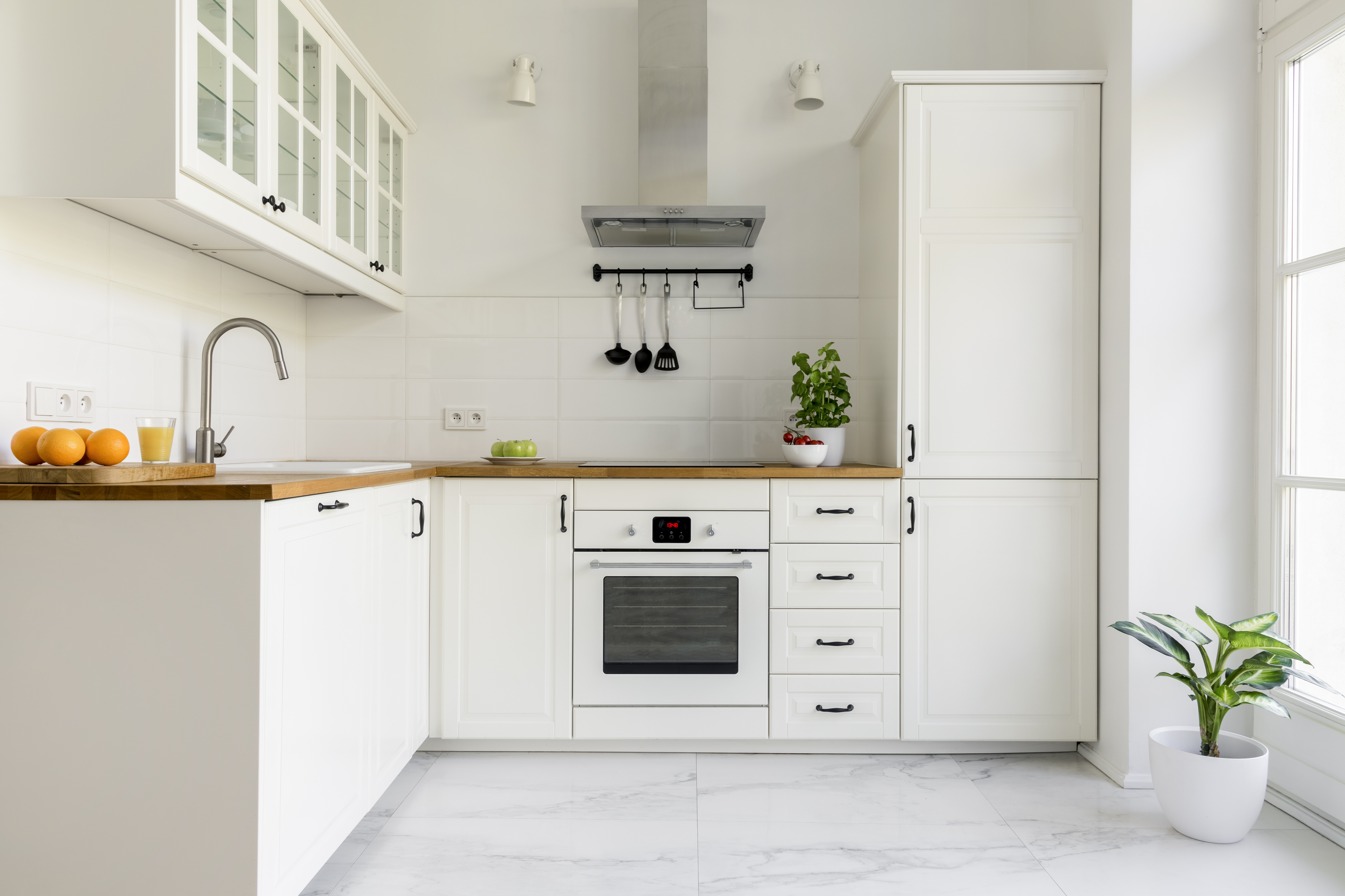 A white built-in oven installed next to white cabinets