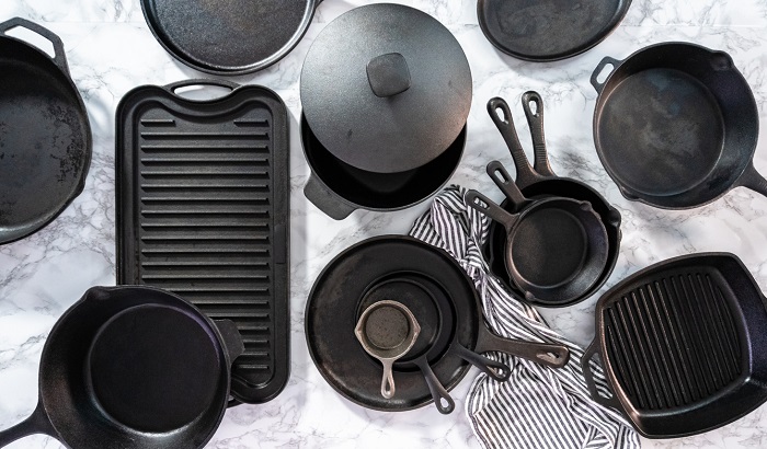 Variety of cast iron frying pans on a marble background.