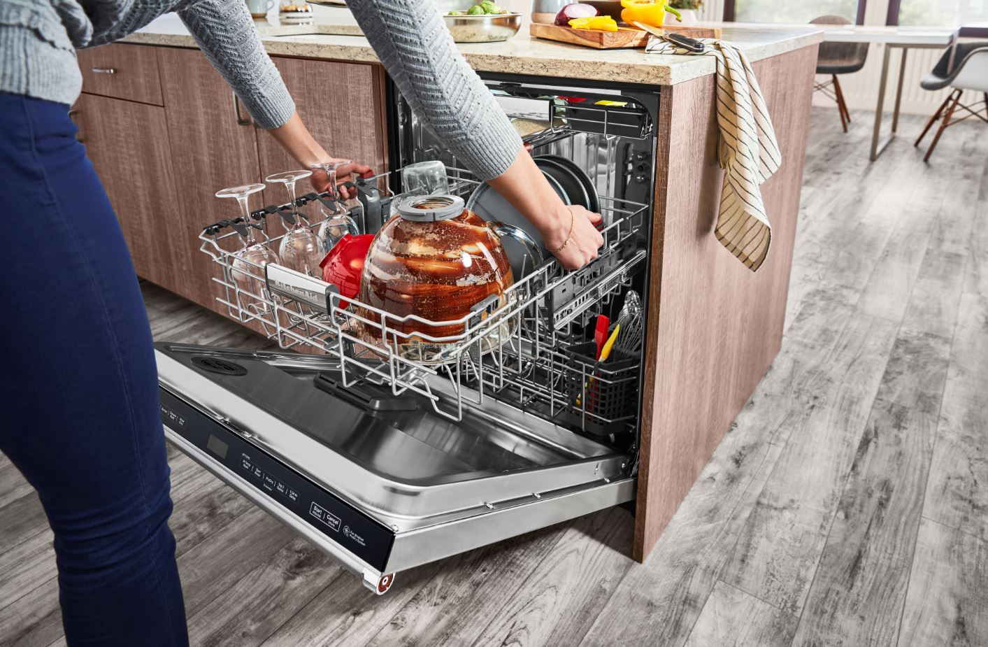 woman takes out third rack from KitchenAid dishwasher
