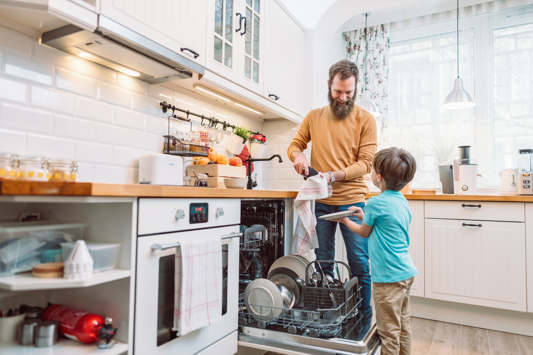 father and son unloading the dishwasher together 