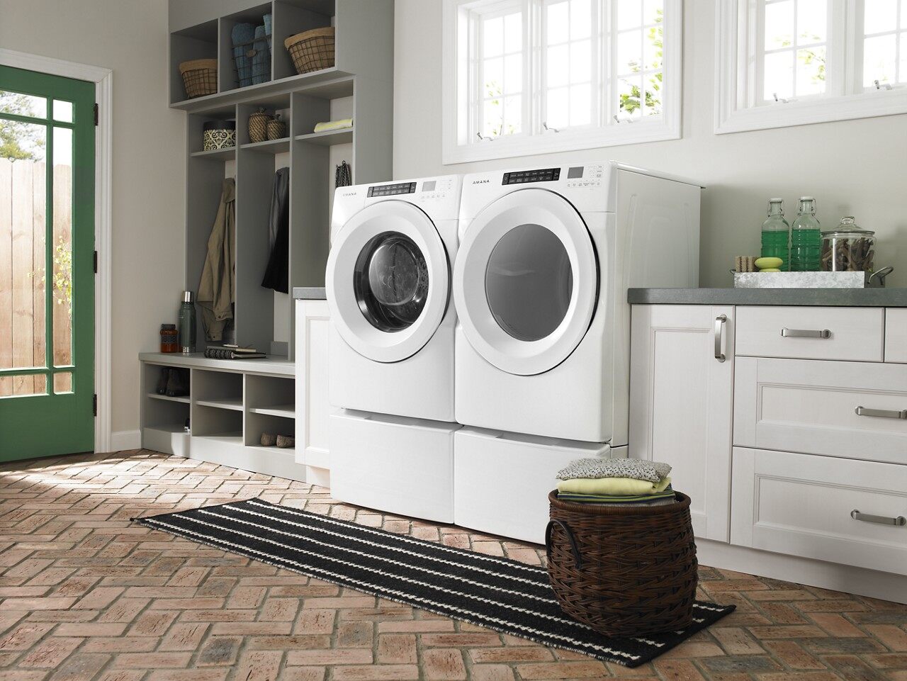 An Amana front load dryer with a matching washer in a laundry room