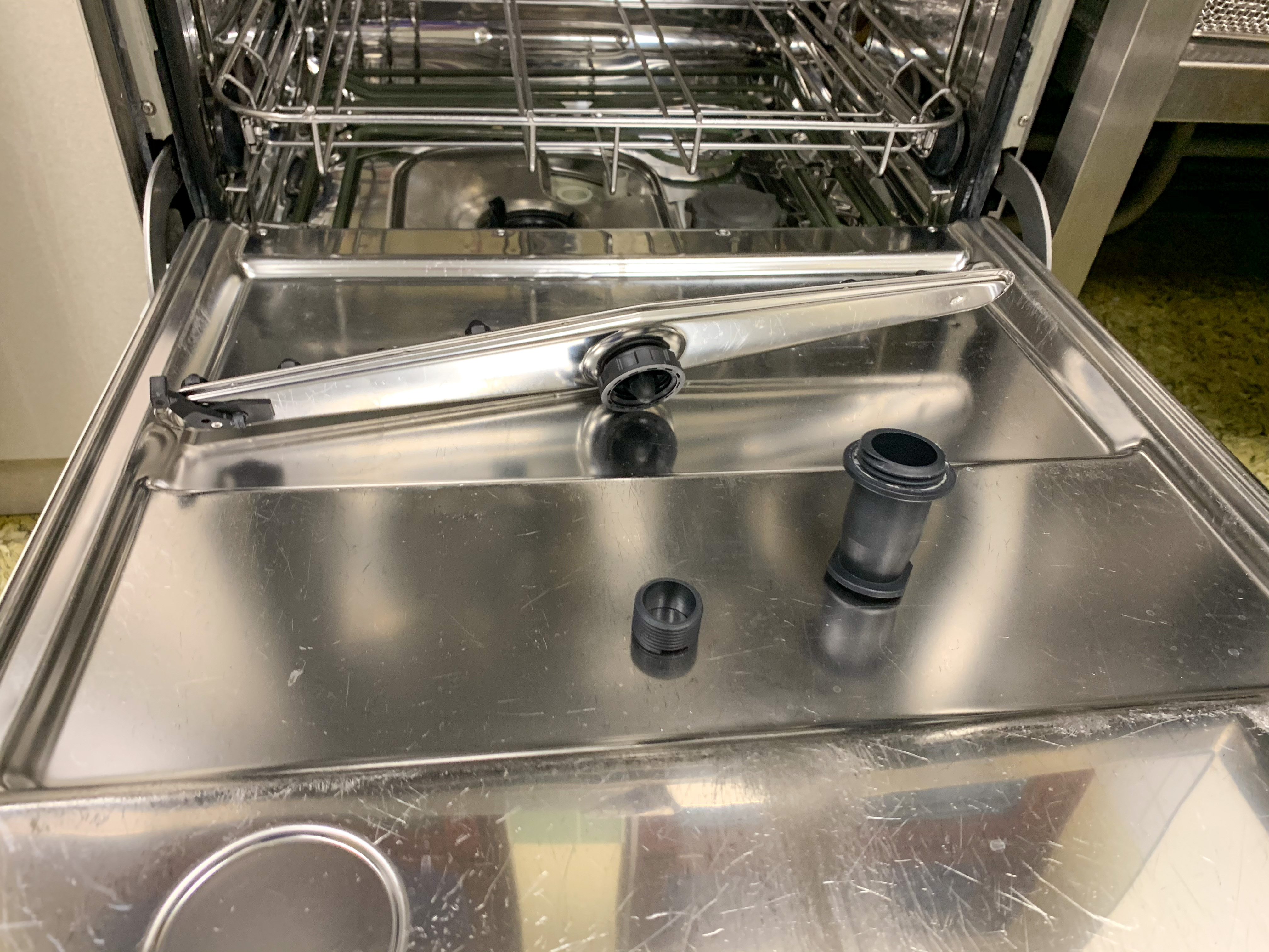 Detached dishwasher spray arm on a dishwasher door 