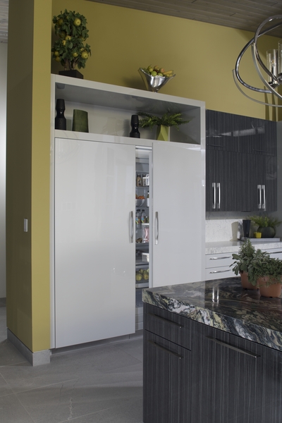 A white Thermador built in refrigerator displayed in a custom kitchen 