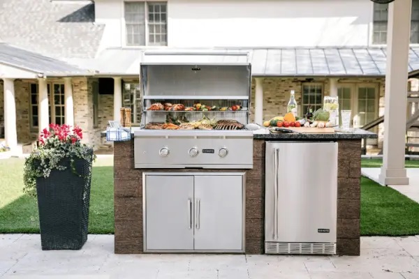 A Coyote charcoal grill installed in an outdoor kitchen island 