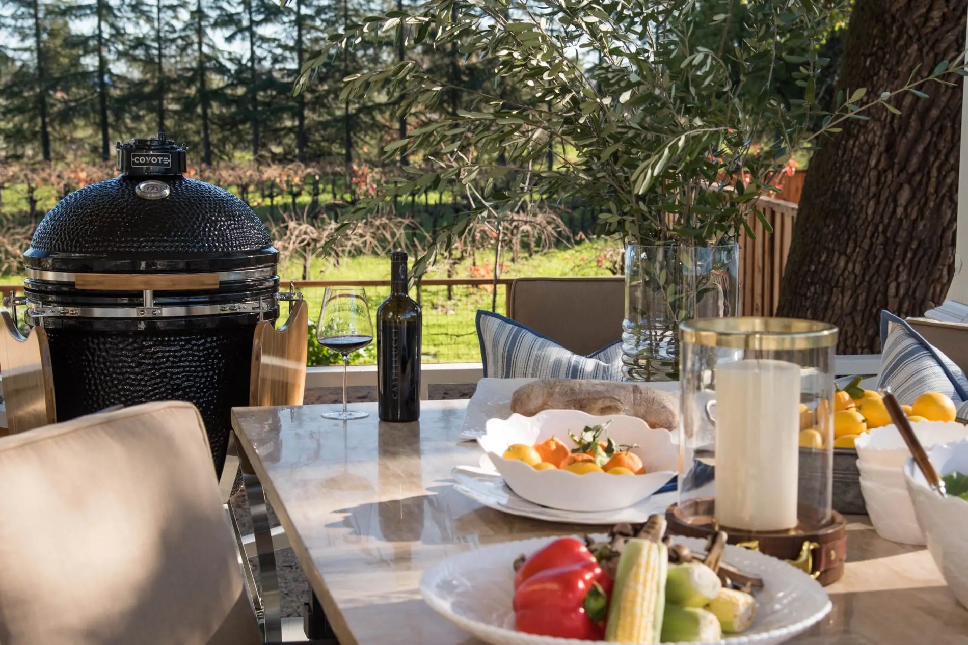 Coyote asado grill featured next to an outdoor table with a variety of foods 