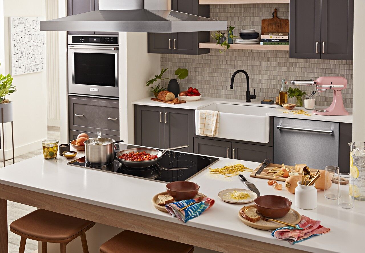 A KitchenAid induction cooktop shown with a variety of cookware 