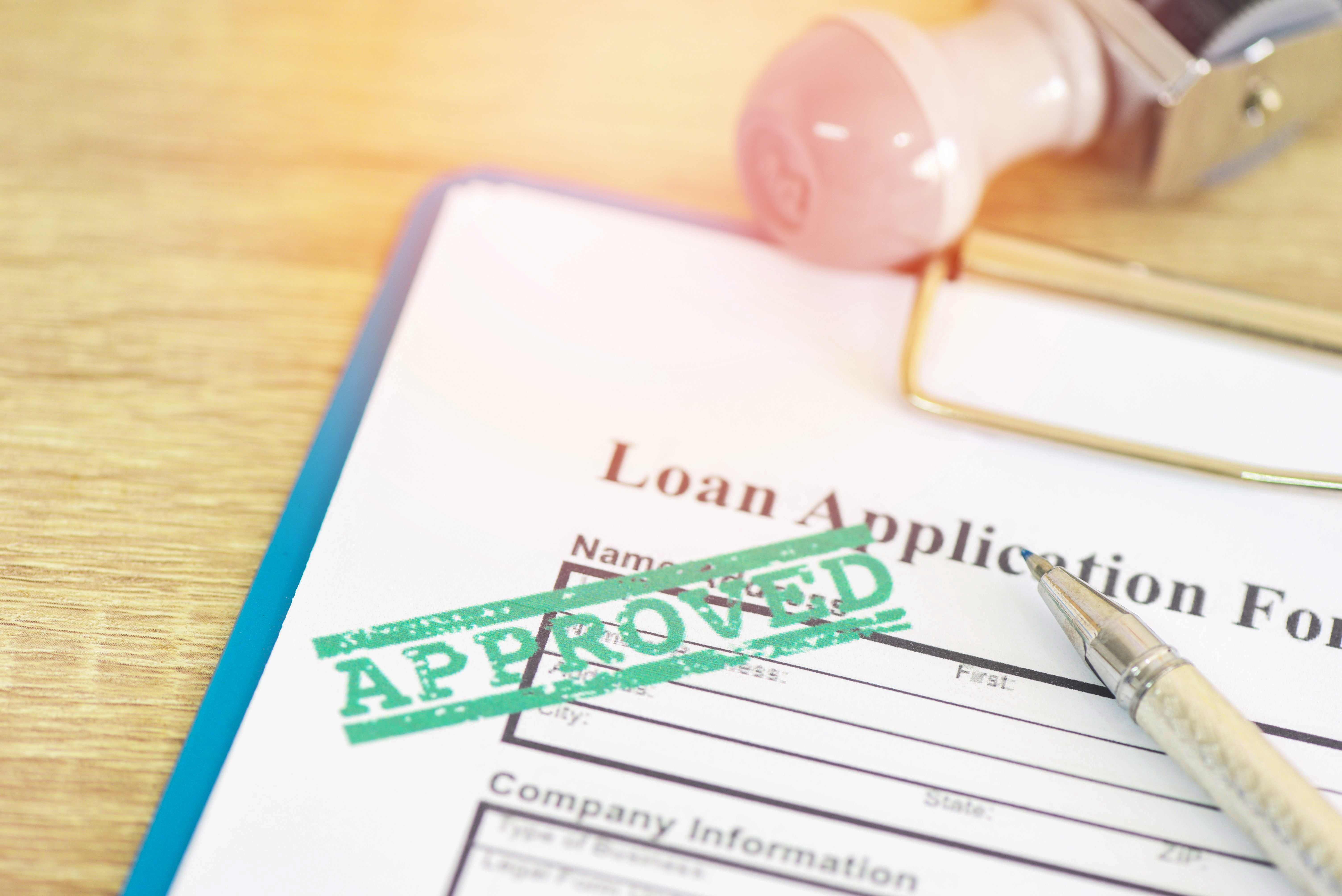 Loan application with a green APPROVED stamp 