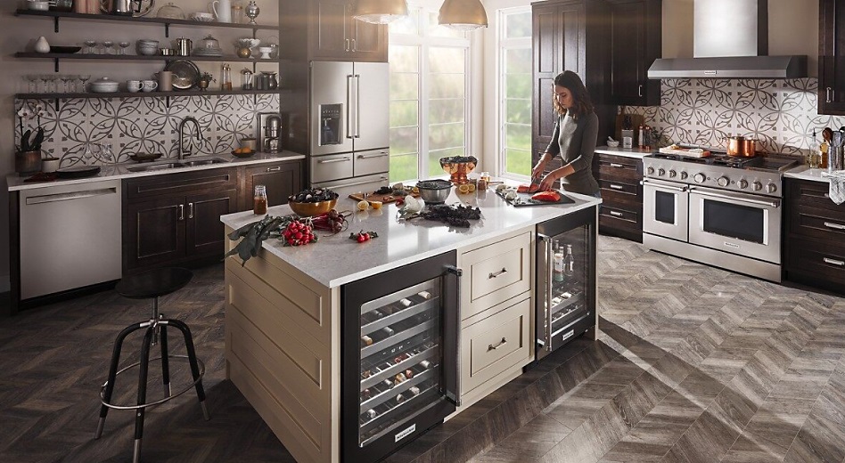 Woman preparing food in a kitchen featuring KitchenAid appliances