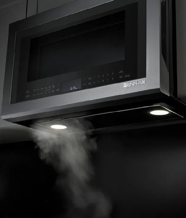 The JennAir JMV9196CS over the range microwave showing filtering smoke against a black background 