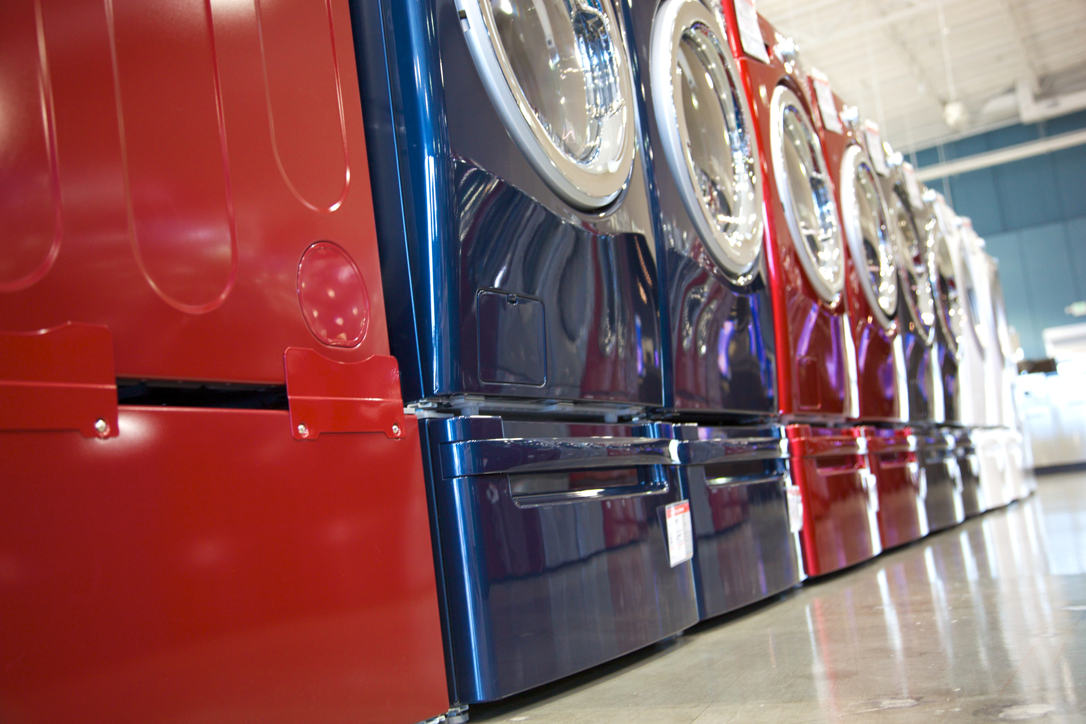 row of red and blue washing machines in an appliance showroom 