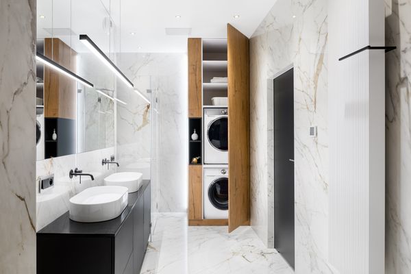 A high-end bathroom featuring a laundry closet with a stackable washer dryer set