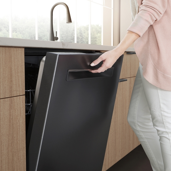 A woman opening a black Bosch dishwasher 