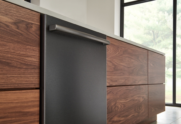 A close-up of a black Bosch dishwasher against wooden cabinetry  