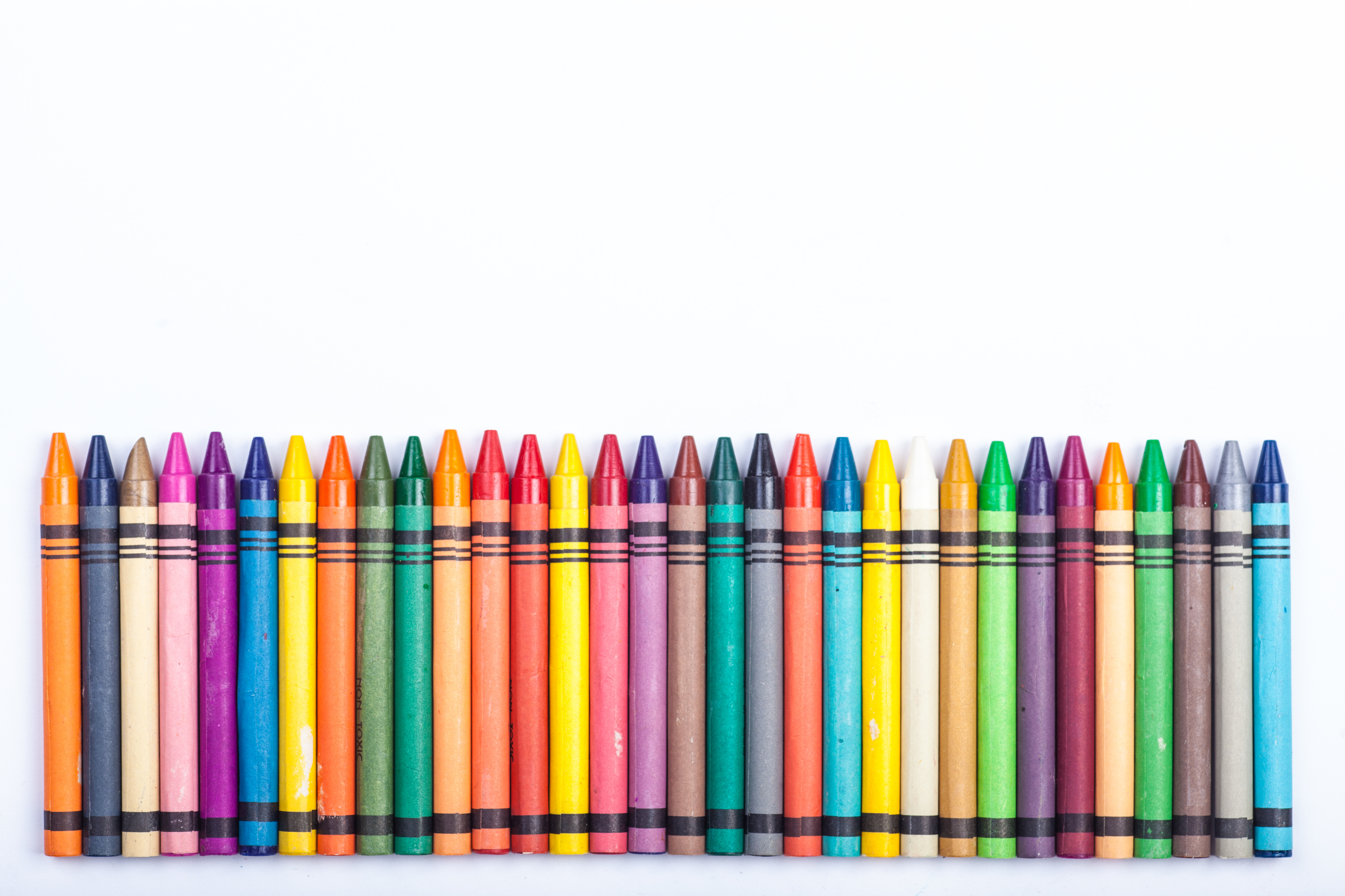 A row of crayons on a white background