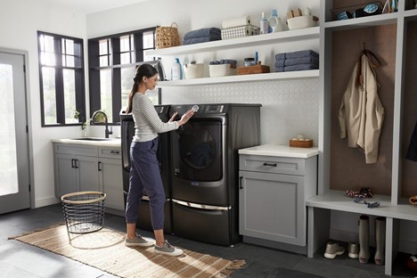A woman using a front load Maytag dryer 